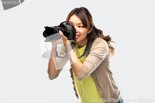 Image of asian female photographer with digital camera