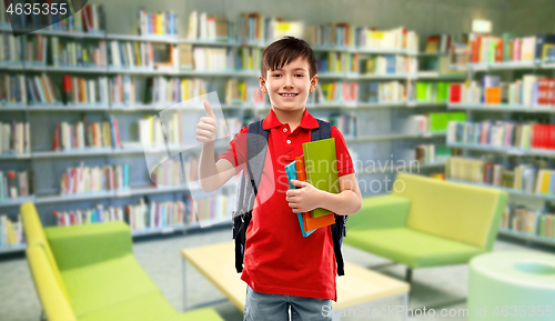 Image of schoolboy with books showing thumbs up at library