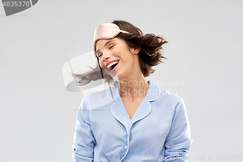 Image of happy young woman in pajama and eye sleeping mask