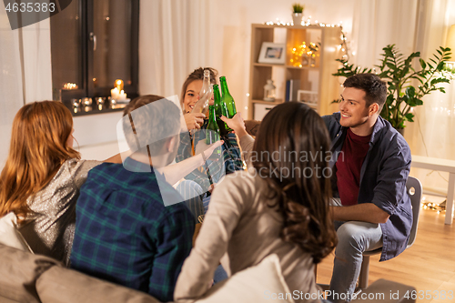 Image of friends clinking drinks at home in evening