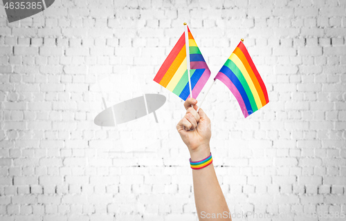 Image of hand with gay pride rainbow flags and wristband