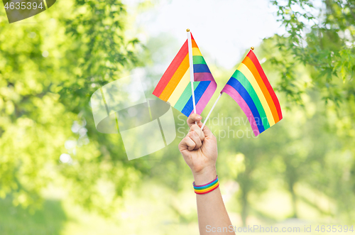 Image of hand with gay pride rainbow flags and wristband