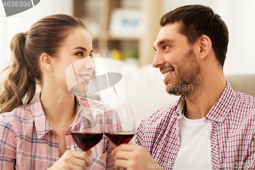 Image of happy couple drinking red wine at home