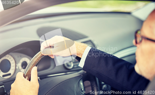 Image of senior businessman hands driving car