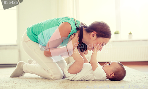 Image of happy mother playing with baby at home