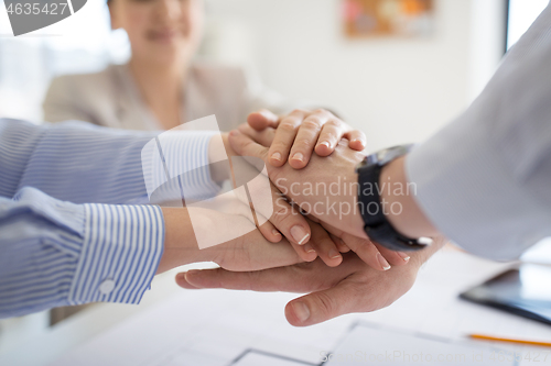 Image of close up of business team stacking hands