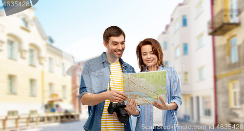 Image of couple of tourists with map and camera in city