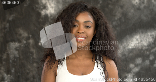 Image of Positive black woman against gray wall
