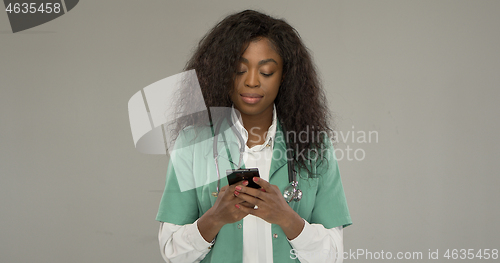 Image of Black medical practitioner using smartphone