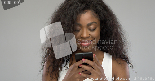 Image of Happy African American woman using smartphone