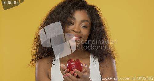 Image of Positive ethnic female sharing apple with camera