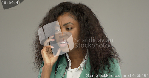 Image of Displeased black doctor answering phone call