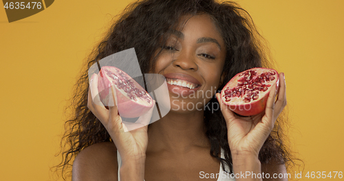 Image of Pleased black woman with pomegranate