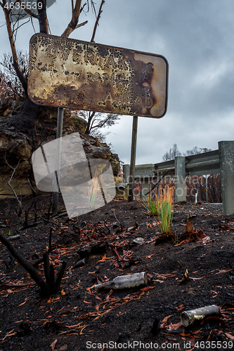 Image of Burnt road sign, rubbish and landscape after bush fires Australi