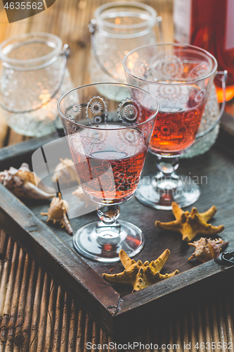 Image of Two vintage glasses of red wine with bottle and lantern