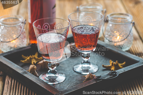 Image of Two vintage glasses of red wine with bottle and lantern