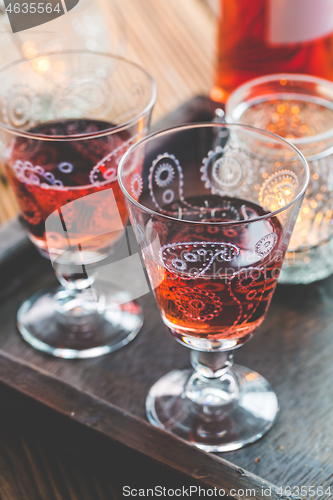 Image of Two vintage glasses of red wine with bottle and lantern