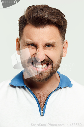 Image of The young emotional angry man screaming on studio background