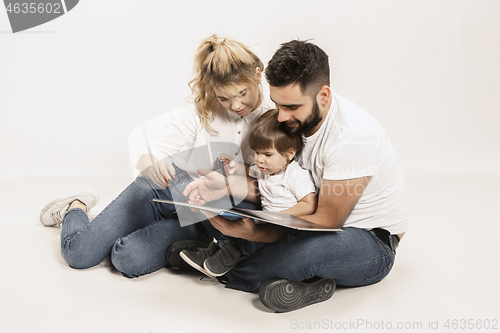 Image of happy family with kid sitting together and smiling at camera isolated on white