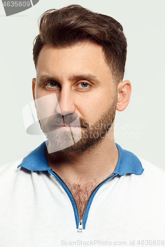 Image of The serious man standing and looking at camera against white background.