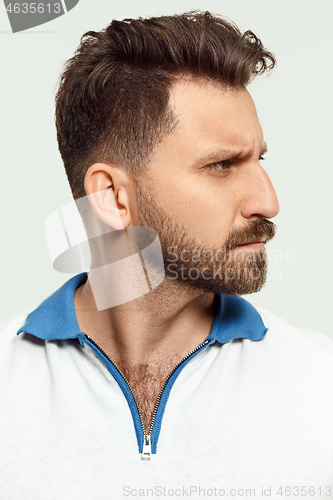 Image of The serious man standing and looking at camera against white background.