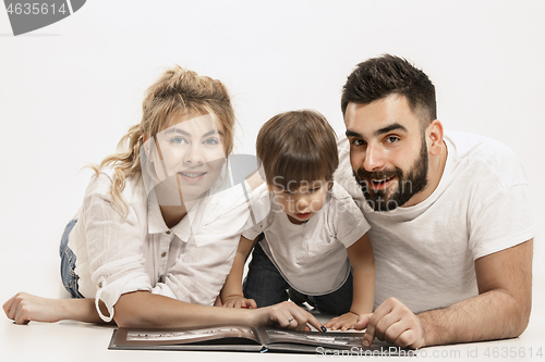 Image of happy family with kid sitting together and smiling at camera isolated on white