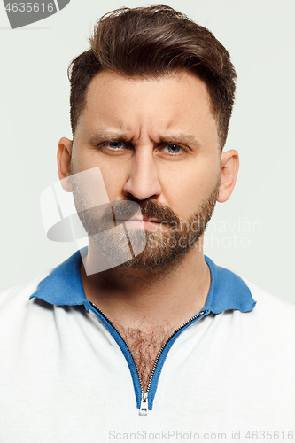 Image of The serious man standing and looking at camera against white background.