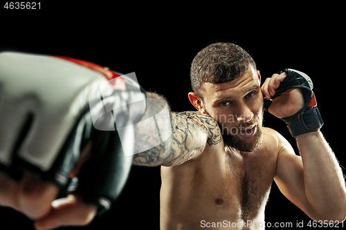 Image of professional boxer boxing isolated on black studio background