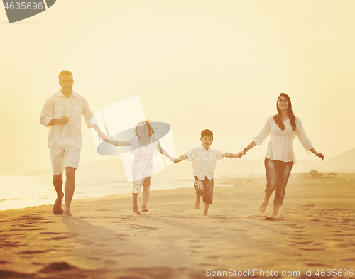 Image of happy young family have fun on beach at sunset