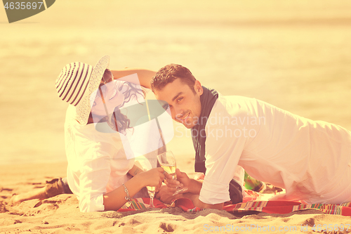 Image of young couple enjoying  picnic on the beach