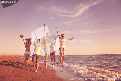 Image of people group running on the beach