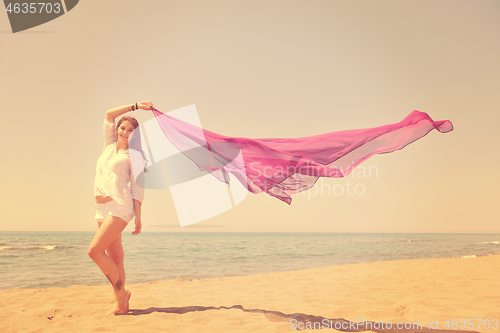 Image of beautiful young woman on beach with scarf