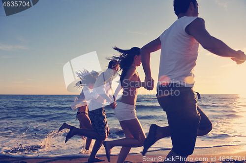 Image of people group running on the beach