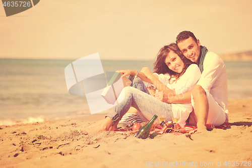 Image of young couple enjoying  picnic on the beach