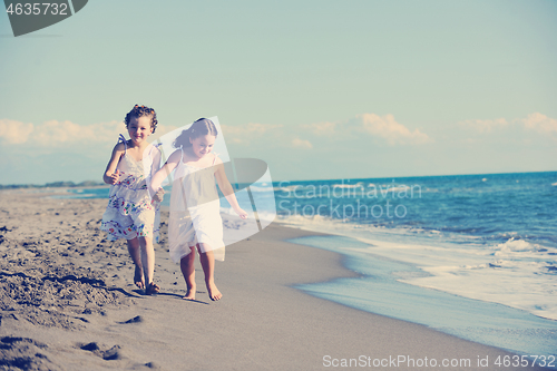 Image of cute little girls running on beach