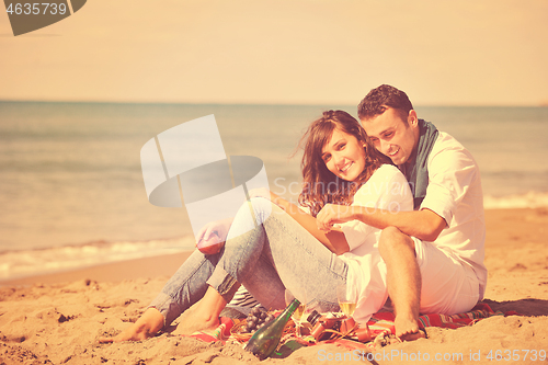 Image of young couple enjoying  picnic on the beach