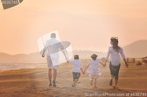 Image of happy young family have fun on beach at sunset