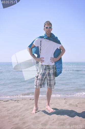 Image of funny superhero standing on beach