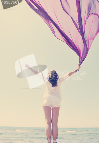 Image of beautiful young woman on beach with scarf