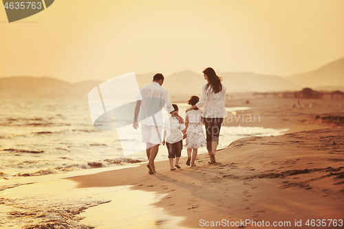 Image of happy young family have fun on beach at sunset