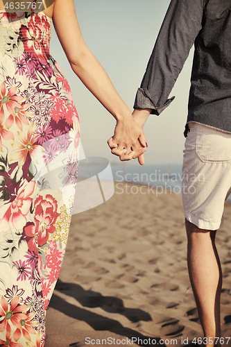 Image of couple on beach with travel bag