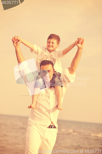 Image of happy father and son have fun and enjoy time on beach