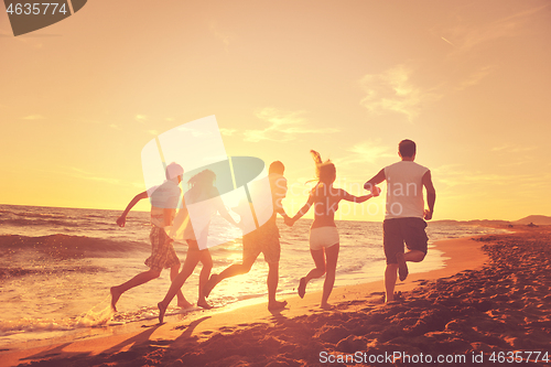 Image of people group running on the beach