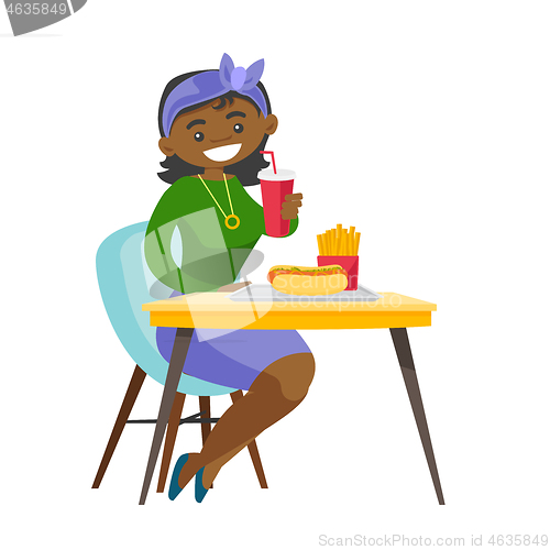 Image of Young african-american woman eating fast food.
