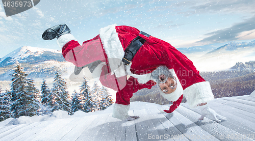 Image of Santa Claus with traditional red white costume in front of white snow winter landscape panorama