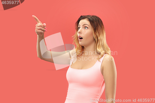 Image of Beautiful woman looking suprised isolated on coral