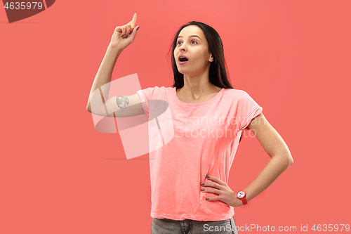 Image of Beautiful woman looking suprised isolated on coral