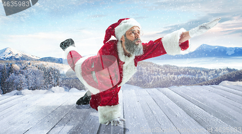 Image of Santa Claus with traditional red white costume in front of white snow winter landscape panorama