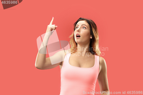 Image of Beautiful woman looking suprised isolated on coral