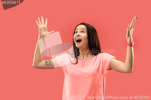 Image of Beautiful woman looking suprised isolated on coral